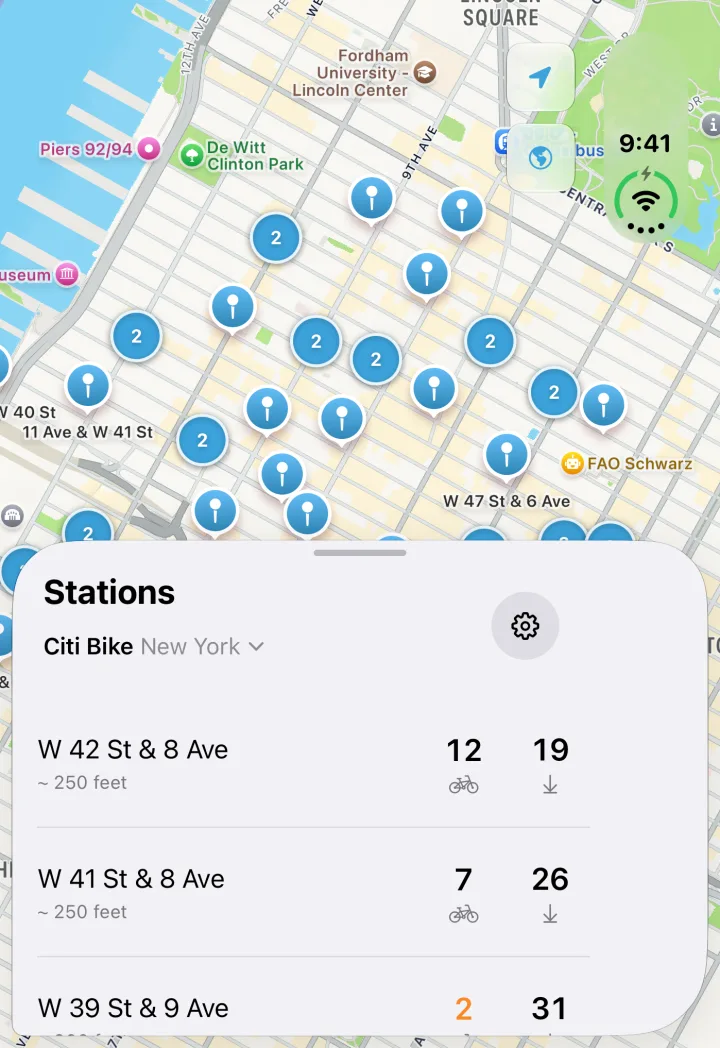 Bike Share Buddy on the iPhone Duo's cover screen, with Citi Bike stations clustered on a map of Midtown Manhattan and the nearest stations listed in a sheet below, each with its bikes and open docks.